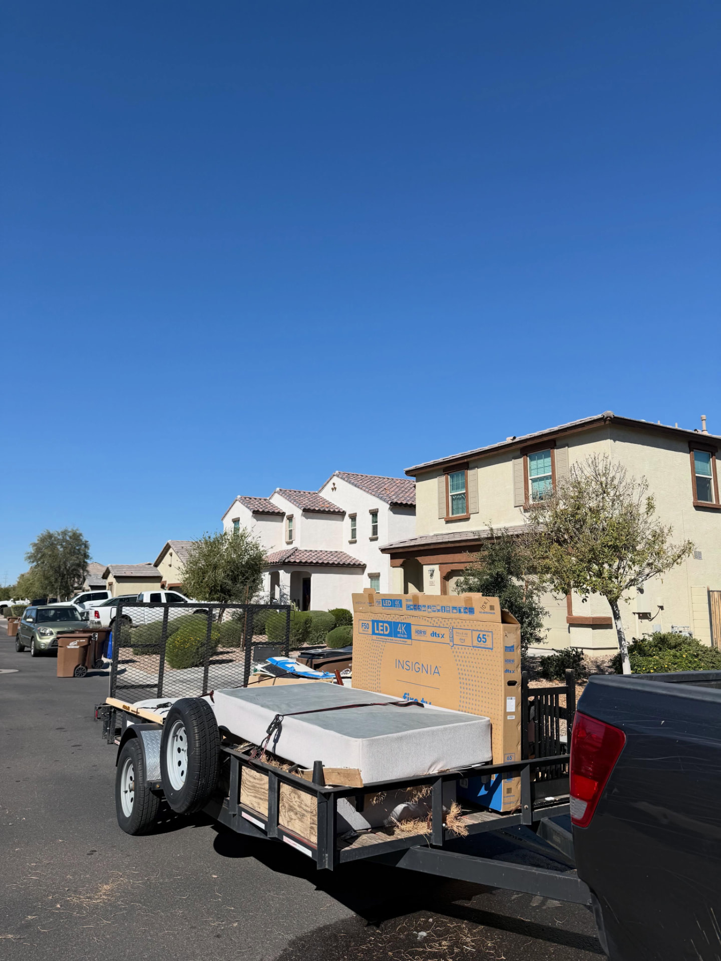 EJ's truck and loaded utility trailer on a residential street in San Tan Valley