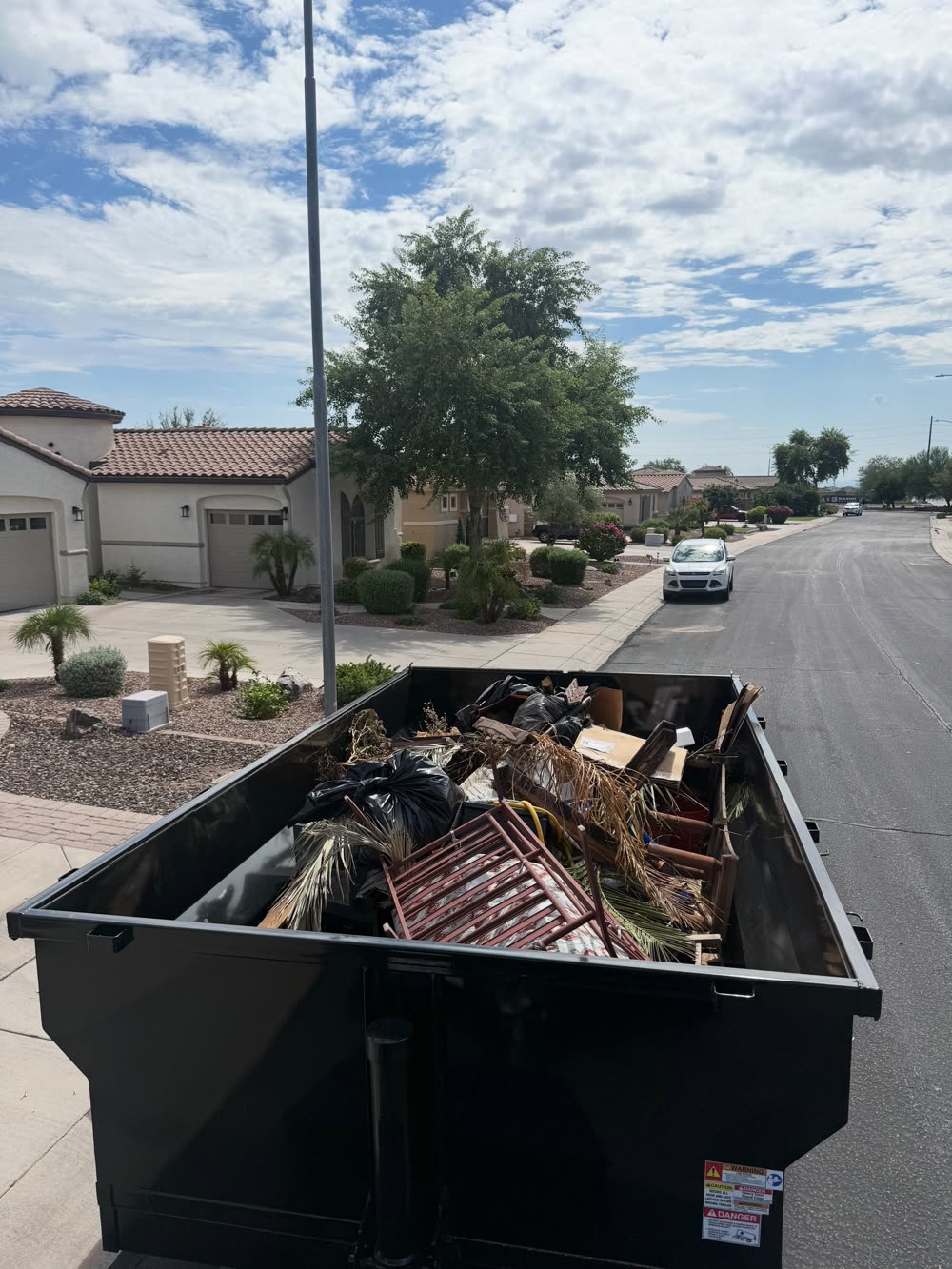 Trailer filled with mixed household debris on a residential street
